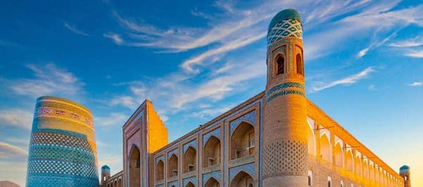 Kalta Minor minaret and madrasah walls, Khiva at sunset