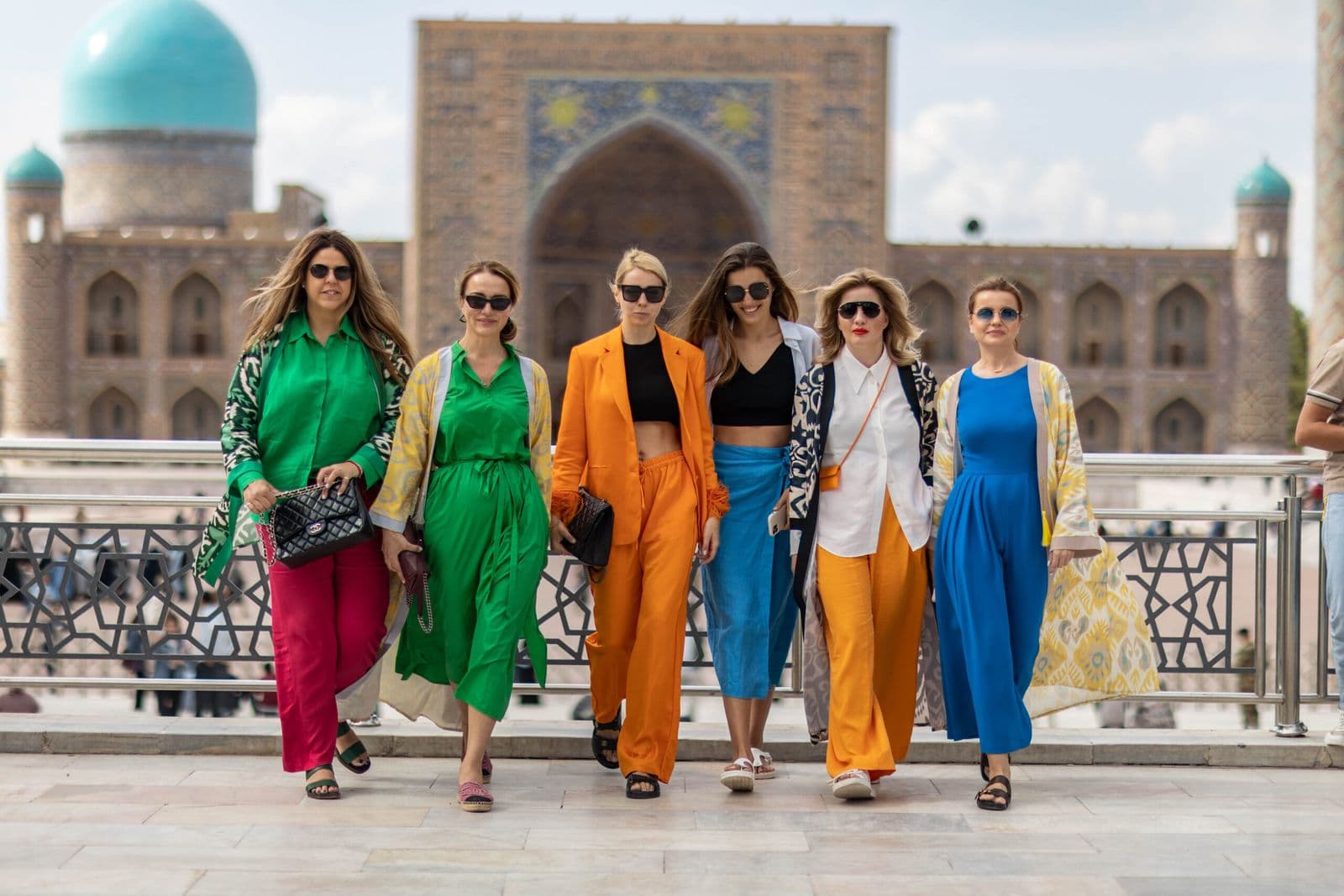 Travellers in bright summer outfits at Registan Square