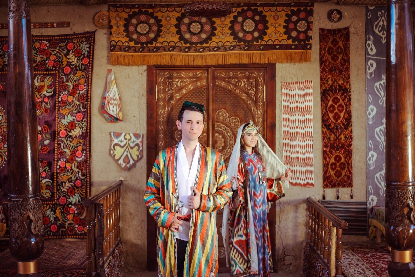 Couple in traditional dress among suzani textiles